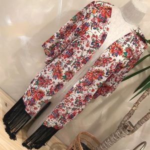 Red paisley print kimono with black fringe.